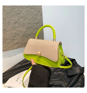 Detail showing neon green leather and straw contrast design with gold buckle closure
