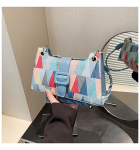 Close-up of geometric triangle pattern and blue woven handle on stylish handbag