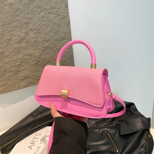 Pink leather and tweed handbag with gold rotary buckle shown in hand for women