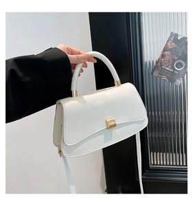 Dettaglio della borsa in pelle PU bianca con fibbia in metallo dorato e manico rigido