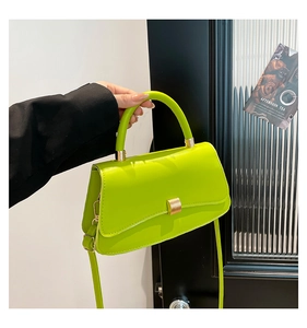 Dettaglio della borsa in pelle PU verde neon con chiusura in metallo dorato su modella