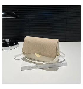 Detail of raffia woven flap and white leather crossbody bag with golden metal buckle