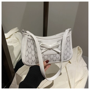 Detail of white PU shoulder bag with M-letter print and 3D bow decoration