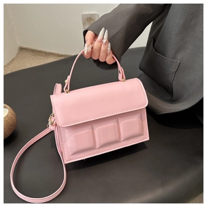 Detail of light pink crossbody bag featuring 3D chocolate block design and thin strap