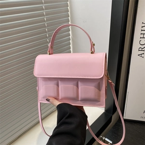 Detail view of pink chocolate-style crossbody bag with unique 3D embossed square textures