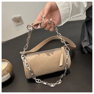 Detail of beige cylinder bag with smooth PU leather finish and silver chain strap