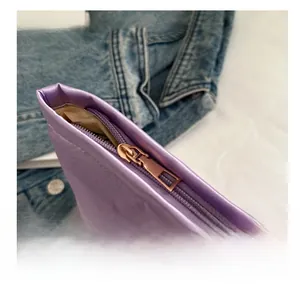 Detail shot of smooth metal zipper and purple satin fabric on elegant clutch bag
