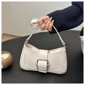Detail of minimalist cream beige shoulder bag featuring a large silver metallic square buckle