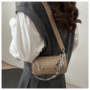 Detail of khaki leather barrel bag with silver chunky chain and broad shoulder strap