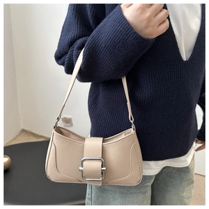 Detail of apricot French style leather underarm bag with silver square metal buckle
