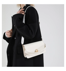 Close-up of white crossbody bag with smooth faux leather texture and golden metal lock