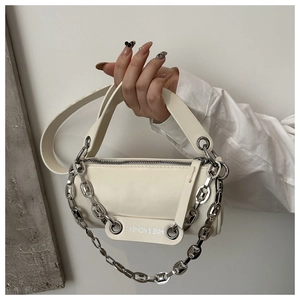 Detail view of cream cylindrical bag featuring a bold silver chain and logo patch