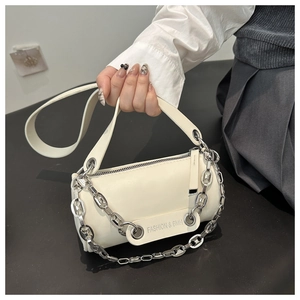 Detail of a beige cylinder crossbody bag featuring a silver chain and printed logo