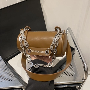 Detail of brown cylinder shoulder bag featuring chunky silver chain and FASHION lettering