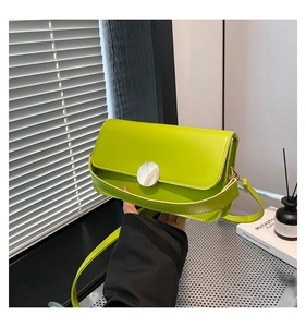 Detailed view of lime green PU leather shoulder bag with a large silver round metal buckle