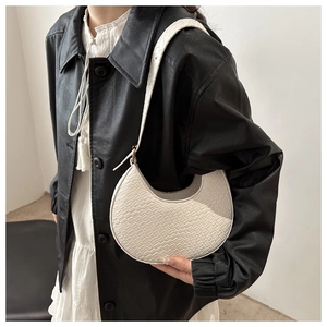 Détail du sac hobo blanc en croissant avec texture tressée et bandoulière sur le modèle