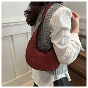 Détail du sac hobo bordeaux montrant le motif tressé complexe et la bandoulière en cuir