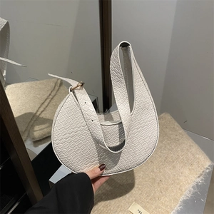 Détail du sac croissant blanc avec texture croco et bandoulière réglable chic