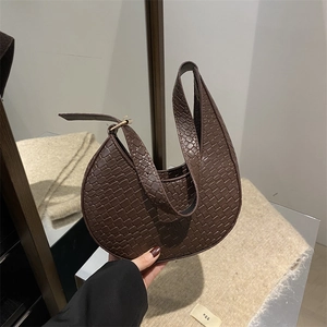 Détail de la texture tressée marron foncé et de la bandoulière réglable du sac lune