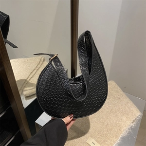 Détail du sac croissant noir avec texture tressée et boucle en métal doré chic