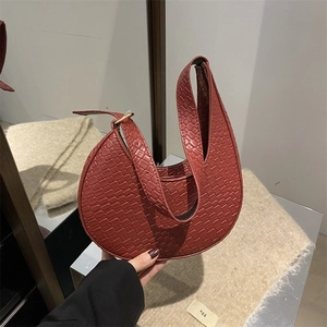 Détail du sac croissant bordeaux avec texture crocodile et bandoulière en cuir réglable