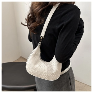 Detail of white woven crescent hobo bag with gold hardware and fine grid texture