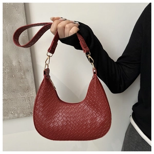 Detail of burgundy hobo bag with woven texture, golden hardware and top zipper closure