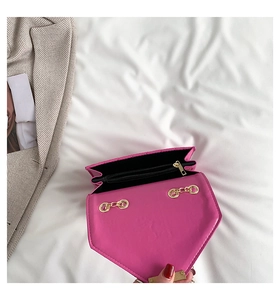 Detail view of fuchsia quilted handbag showing black lining, inner zip pocket and gold hardware
