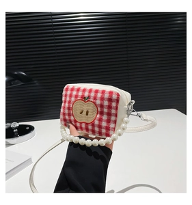 Detail of red checkered small handbag with apple embroidery and pearl bead handle