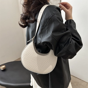 Sac hobo crème tissé minimaliste avec large bandoulière porté par un mannequin