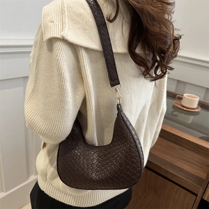 Brown woven crescent shoulder bag in vegan leather with golden metal hardware and strap