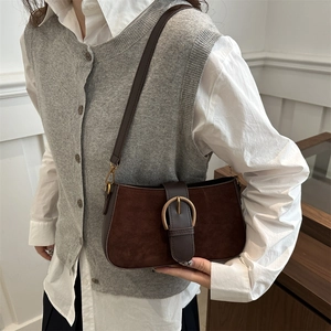 Deep brown matte suede shoulder bag with a gold horseshoe buckle shown on a model