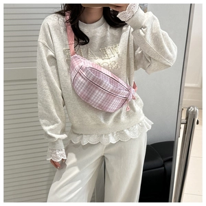 Detailansicht einer rosa-weiß karierten Brusttasche mit verstellbarem rosa Schultergurt