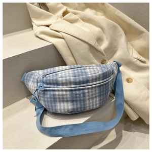 Vue détaillée du sac de poitrine en toile à carreaux bleu et blanc posé sur des marches