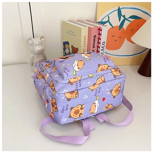 Detail view of purple school backpack with cute capybara print in a study room setting