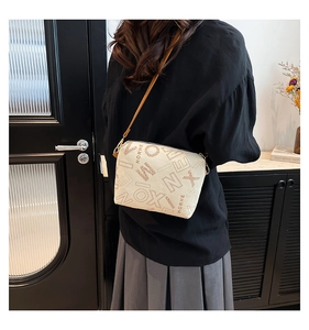 Close-up of beige tote bag with brown letter print and slender leather strap details