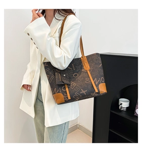 Détail d'un grand sac cabas vintage avec motif de lettres et bordure marron