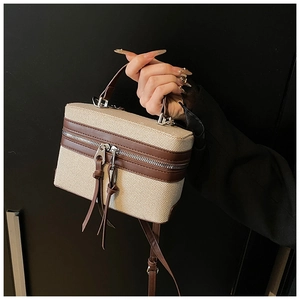 Detail der Canvas Box Bag mit braunem Lederbesatz und modischen langen Quasten-Zippern