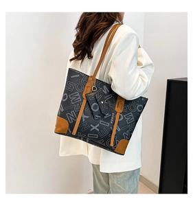Detail of printed tote bag with leather straps and matching coin purse on model
