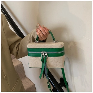 Detailansicht der zweifarbigen Canvas-Leder-Box-Bag an einem Model im Hosenanzug