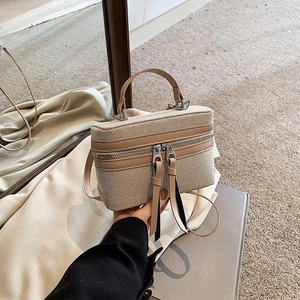 Detail der Vintage-Box-Tasche aus Segeltuch mit beigem Stoff und braunem Lederbesatz