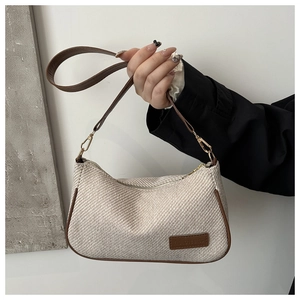 Detail of canvas shoulder bag showing leather trim and Fashion & Bags brand tag