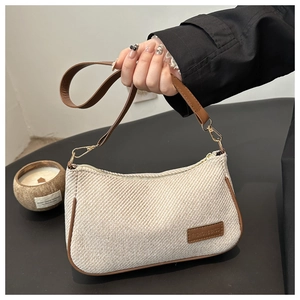 Detail of minimalist cream woven texture with brown leather trim and fashion logo tag