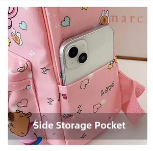 Detail of pink canvas backpack side pocket with cute capybara print holding a smartphone