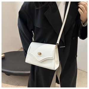 Close-up of white crossbody bag featuring a golden oval twist lock and glossy PU leather