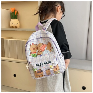 Detail view of purple checkered Capybara backpack worn by a model in a cozy indoor setting