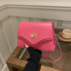 Detail of rose pink rectangular handbag with V-shaped stitching and gold twist lock
