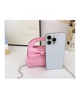 Pink bow mini bag size comparison with a smartphone showing compact dimensions
