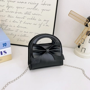 Detail of matte black bow handbag with silver chain strap and rigid circular handle