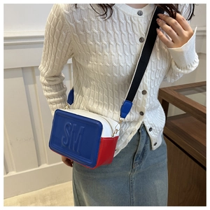 Detailed view of the tricolor square crossbody bag with SM embossed lettering and strap